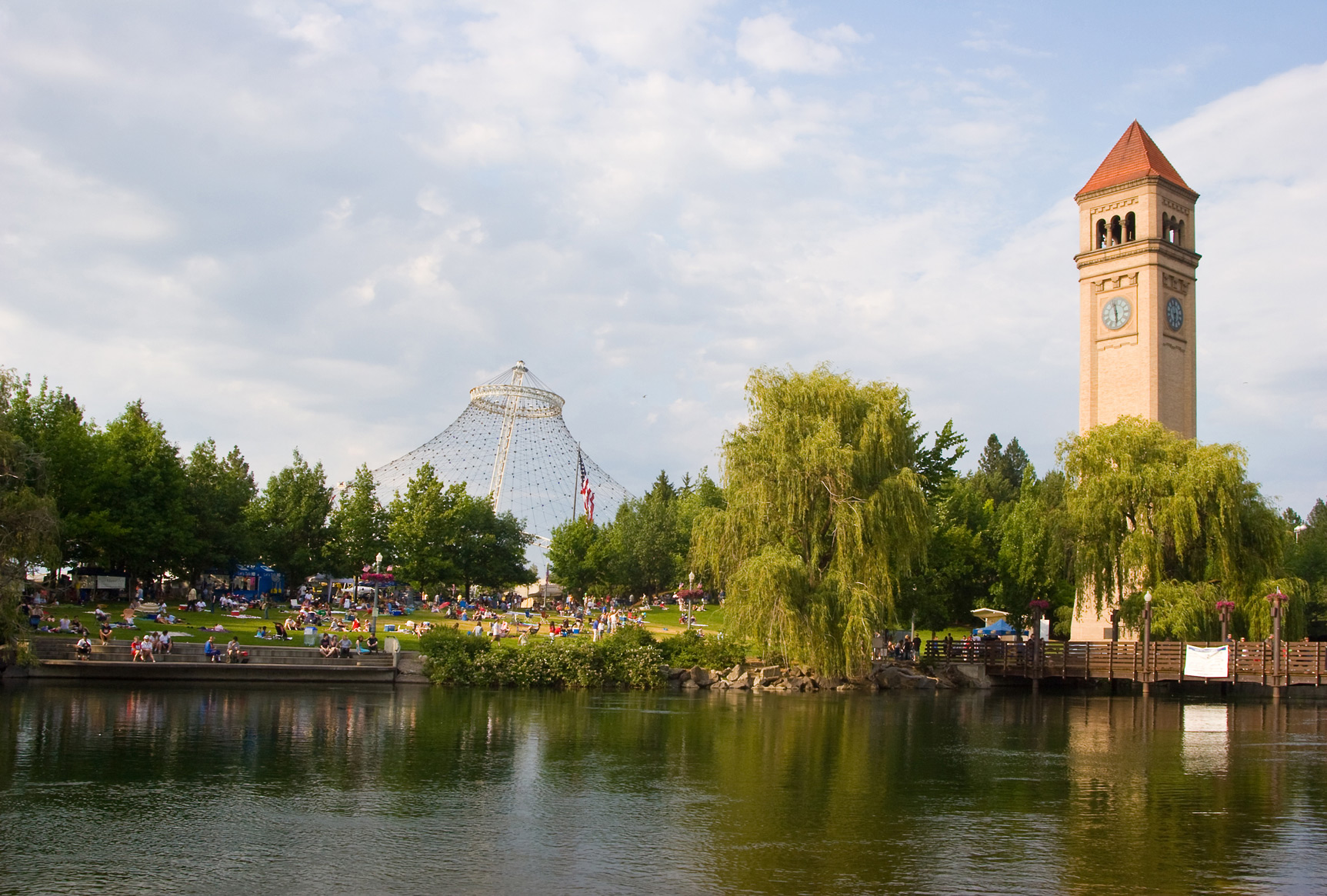 Riverfront Park in downtown Spokane, featuring the Clock Tower, Pavilion structure, trees, and the Spokane River along the park’s edge.