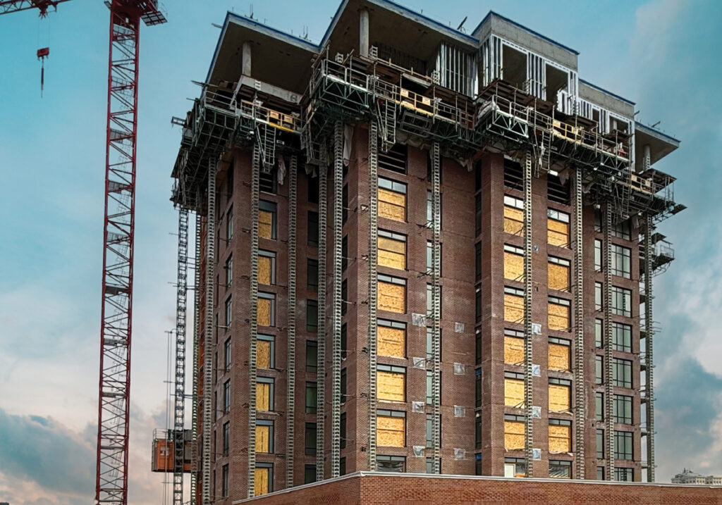 Spokane Falls Tower under construction with crane, brick exterior nearing completion and upper levels actively being built in downtown Spokane.